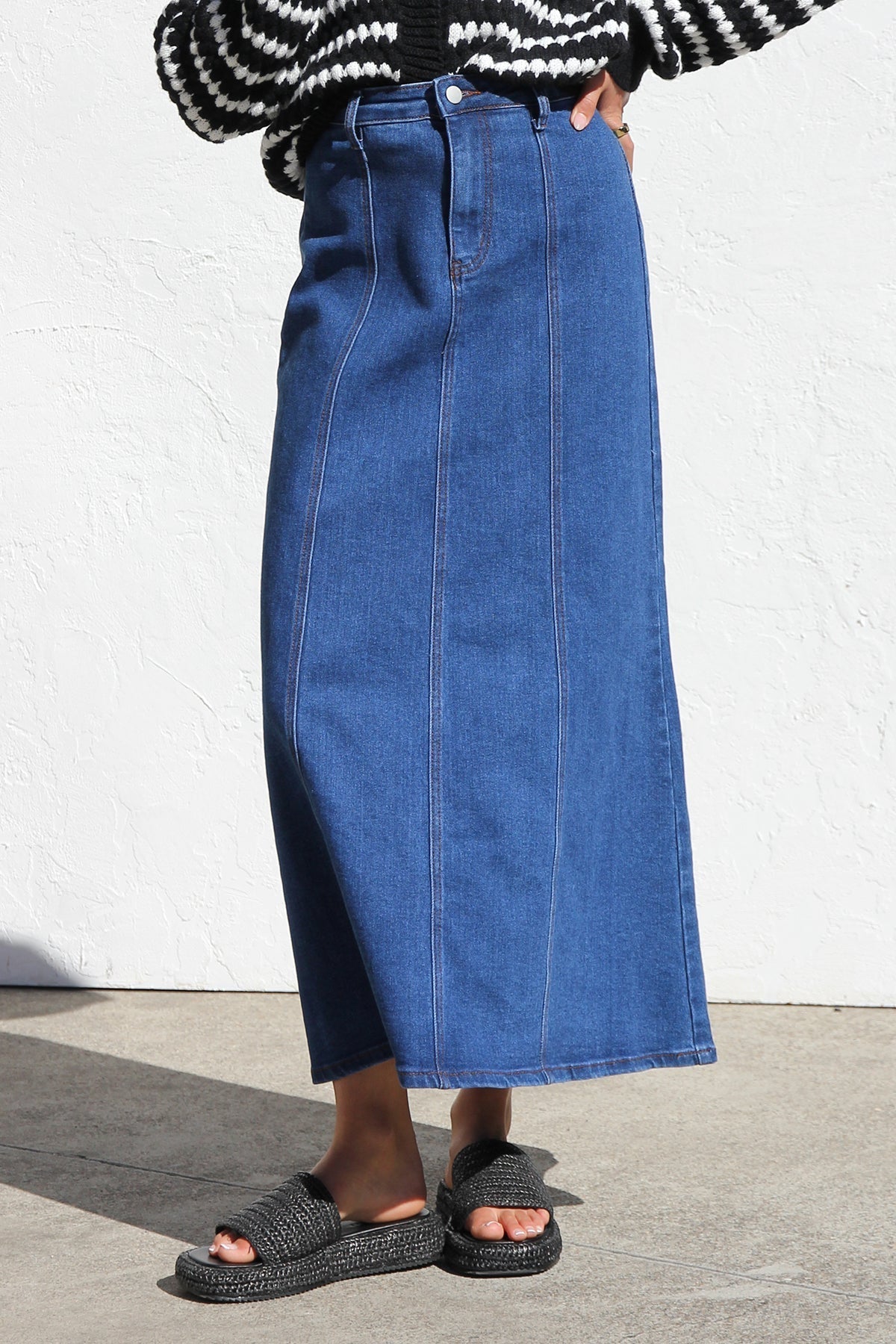 Woman wearing a blue denim maxi skirt with panelled design