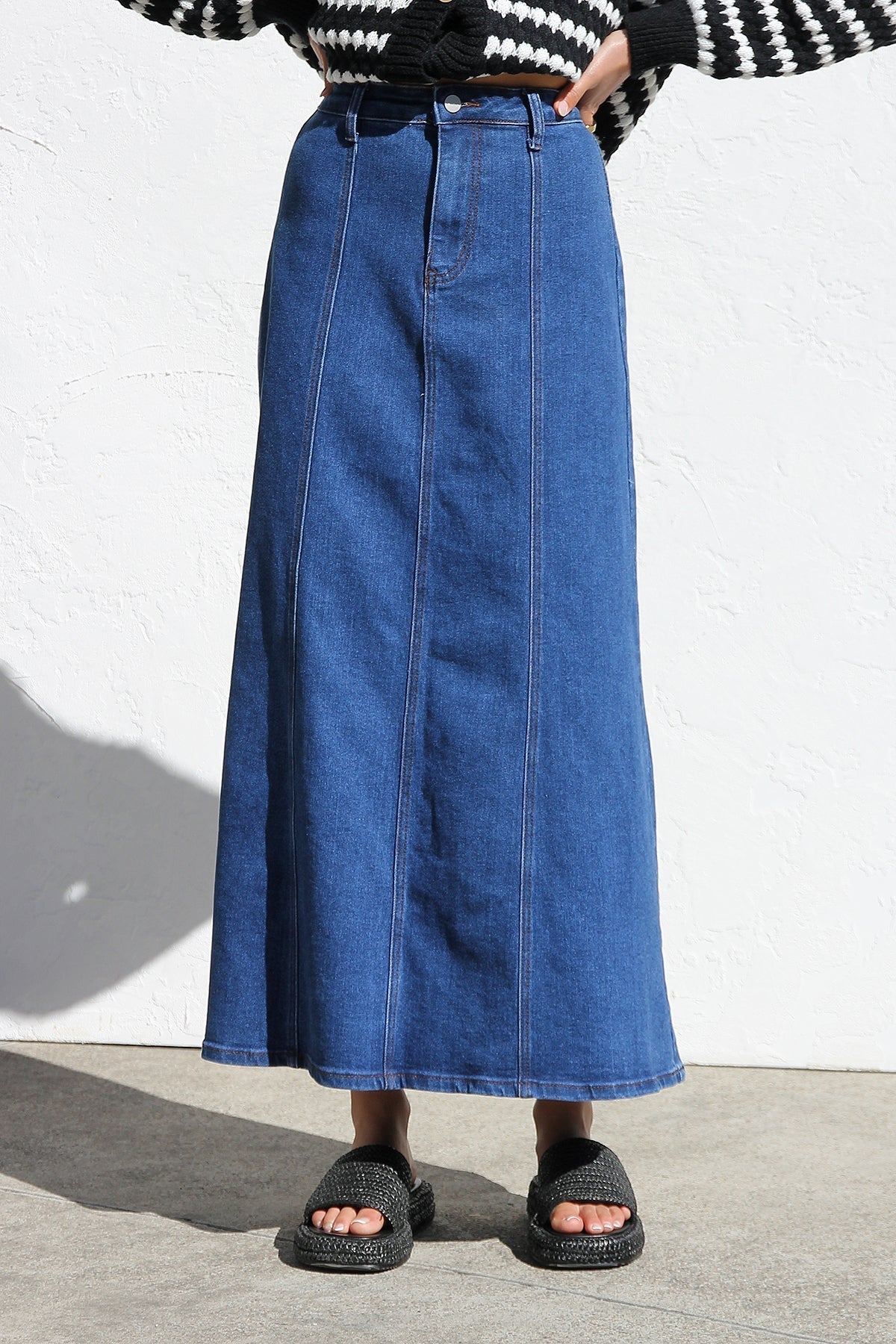 Woman wearing a blue denim maxi skirt with panelled design