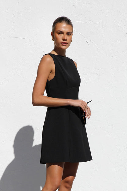 Woman in black sleeveless woven mini dress