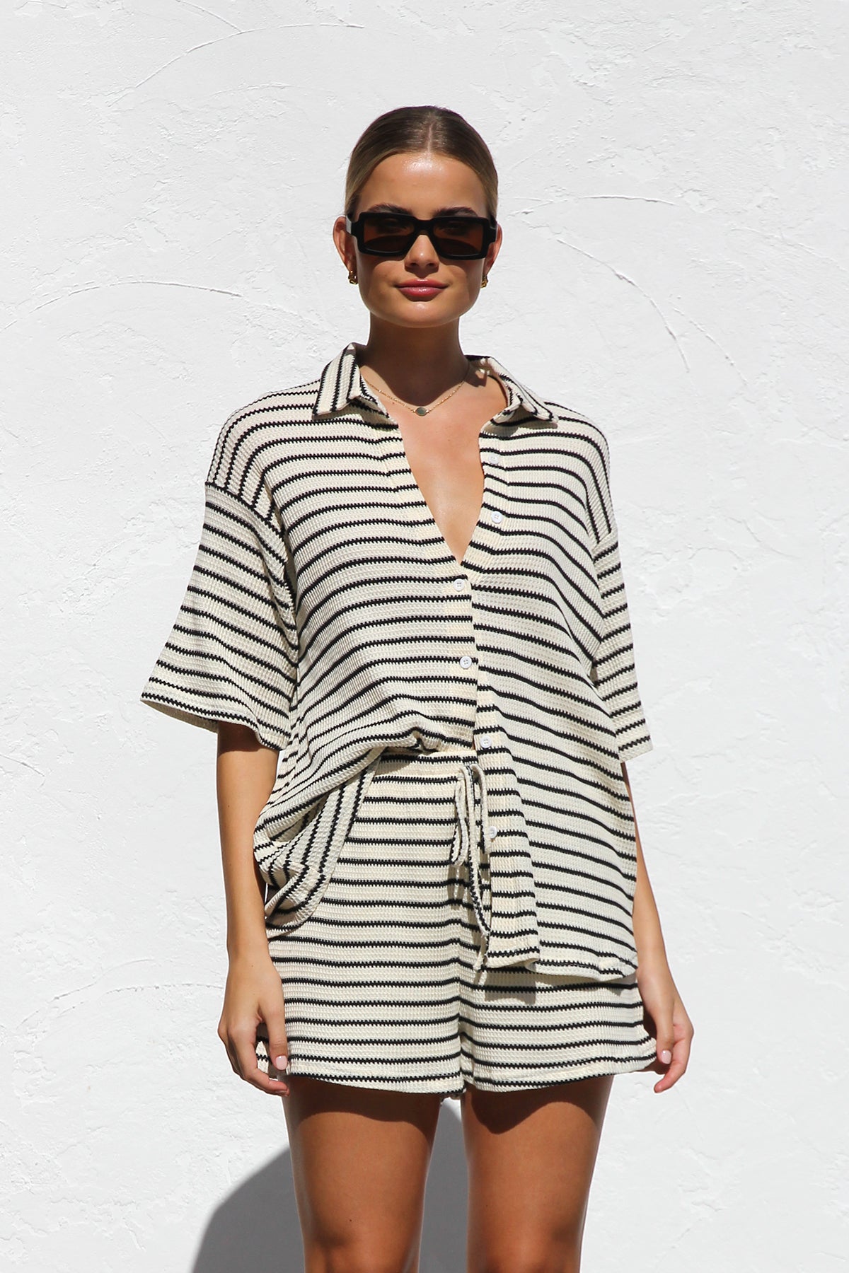 Woman in cream and black striped knit shirt and shorts set