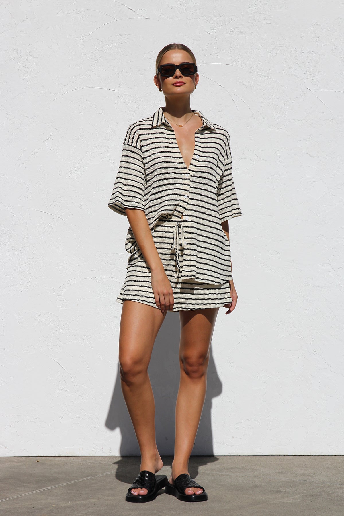 Woman in cream and black striped knit shirt and shorts set