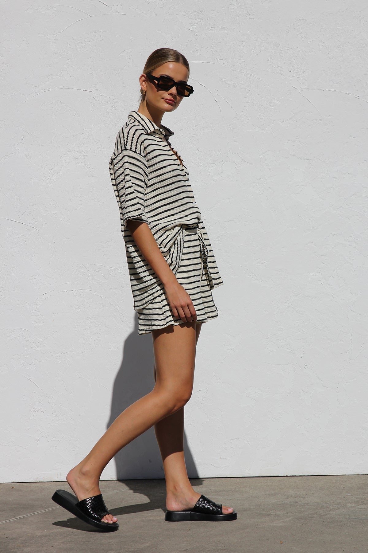 Woman in cream and black striped knit shirt and shorts set