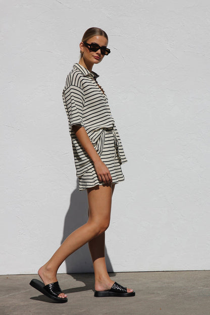 Woman in cream and black striped knit shirt and shorts set
