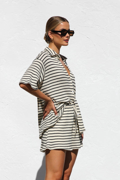 Woman in cream and black striped knit shirt and shorts set