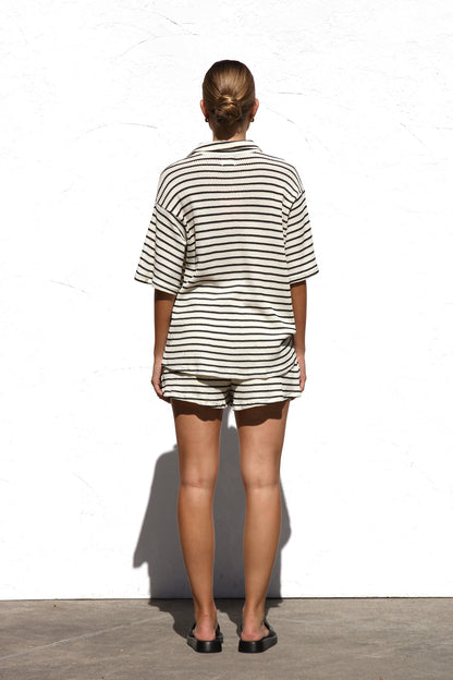 Woman in cream and black striped knit shirt and shorts set