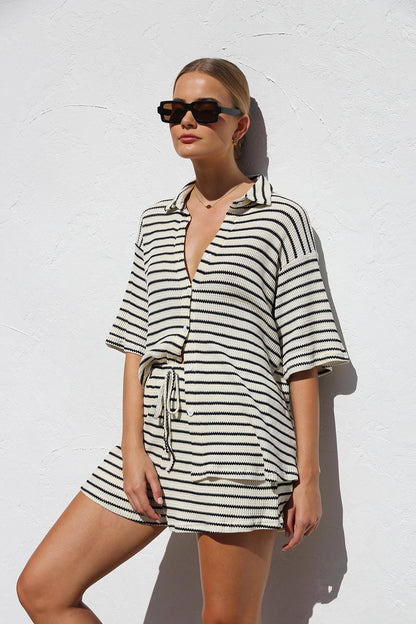 Woman in cream and black striped knit shirt and shorts set