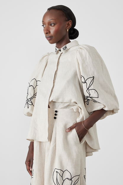 Woman wearing linen pant set with black magnolia embroidery