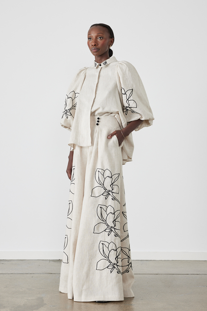 Woman wearing linen pant set with black magnolia embroidery