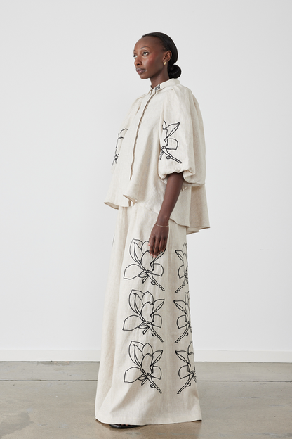 Woman wearing linen pant set with black magnolia embroidery