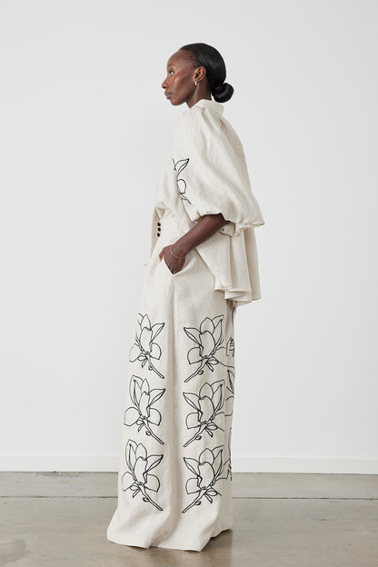 Woman wearing linen pant set with black magnolia embroidery