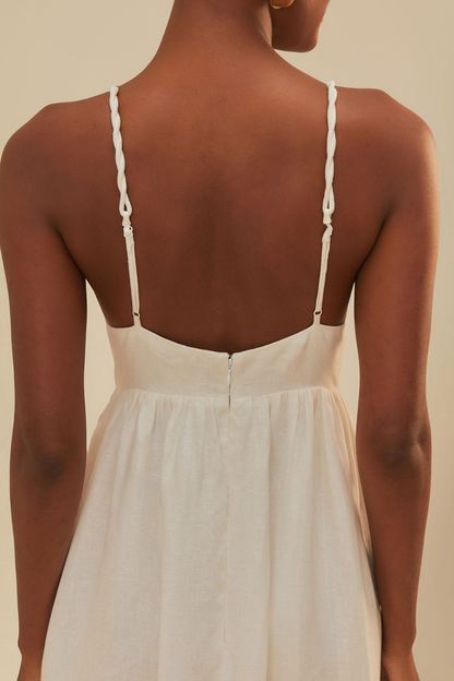 Woman in off-white linen sundress with palm tree appliques