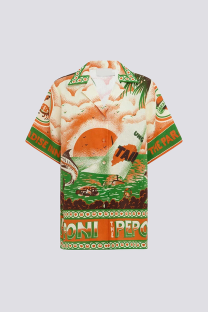 Woman wearing orange and green tropical print short set with black sandals.