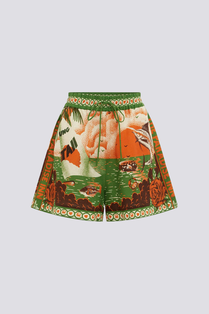 Woman wearing orange and green tropical print short set with black sandals.
