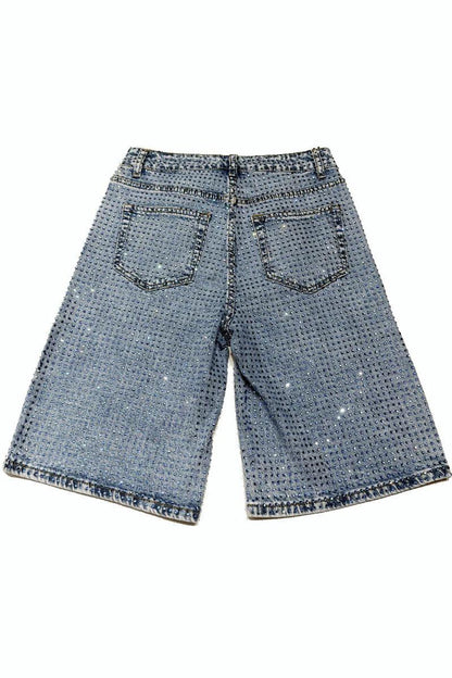Woman wearing light wash denim bermuda shorts with sparkly embellishments