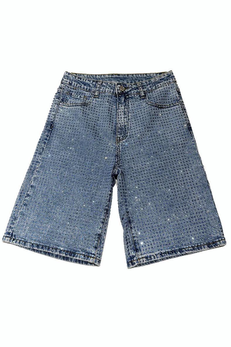 Woman wearing light wash denim bermuda shorts with sparkly embellishments