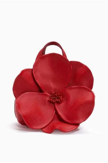 Woman in pink floral chiffon dress holding a red flower-shaped purse