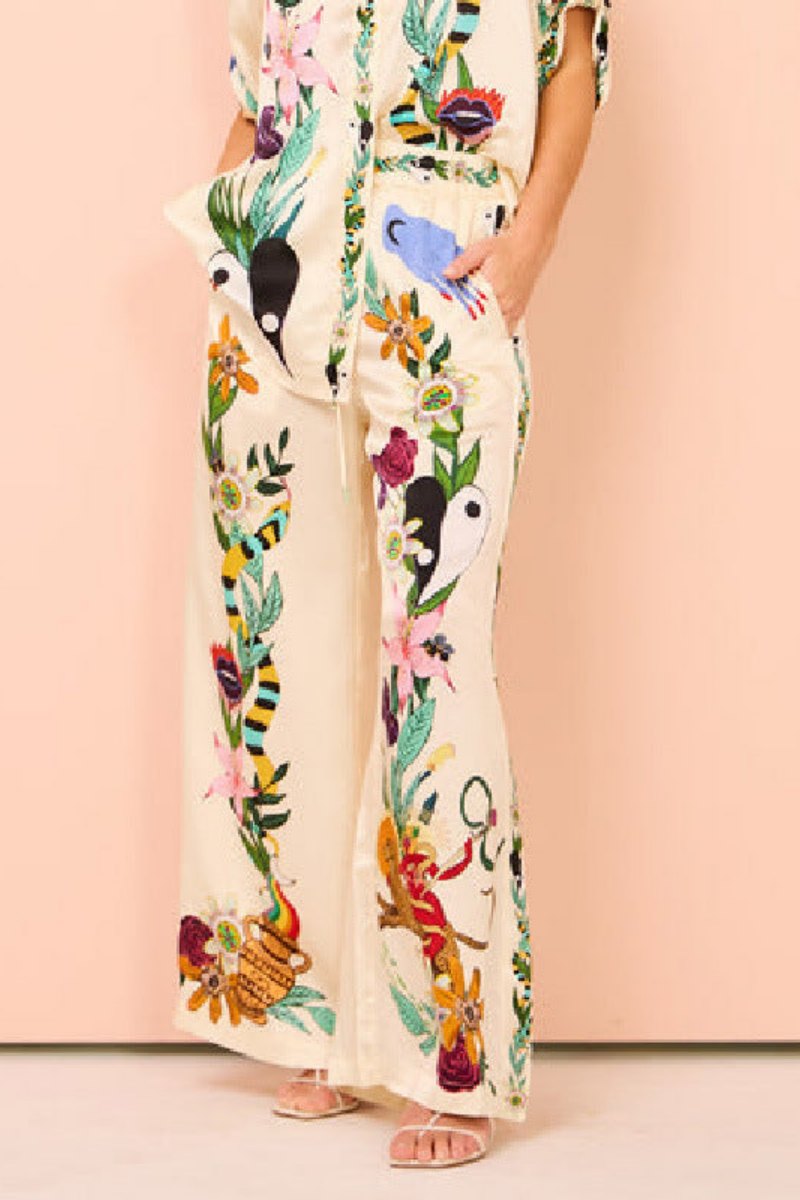 Woman wearing ivory satin pajama set with floral and yin yang print