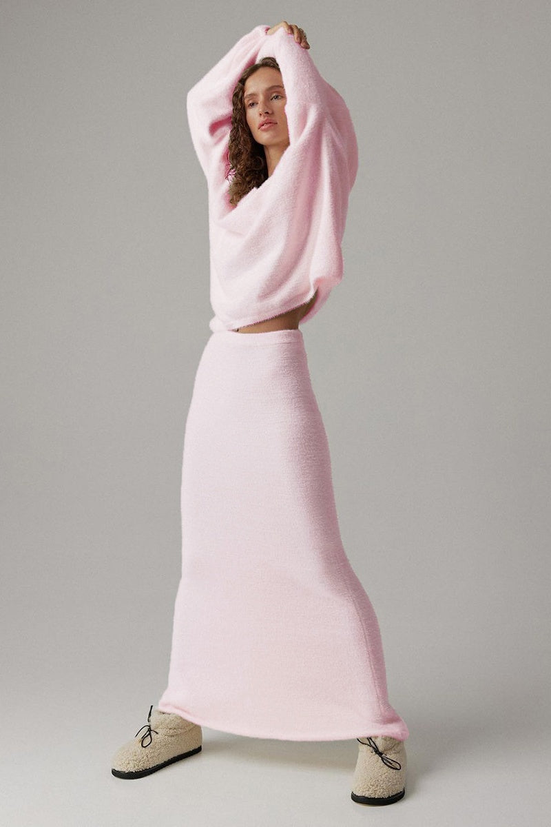Woman in off-white boucle knit sweater and maxi skirt set with fuzzy slippers