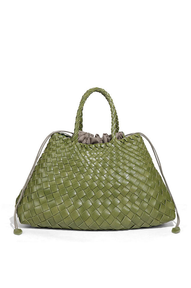Woman holding brown woven tote bag