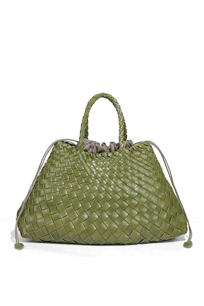 Woman holding brown woven tote bag