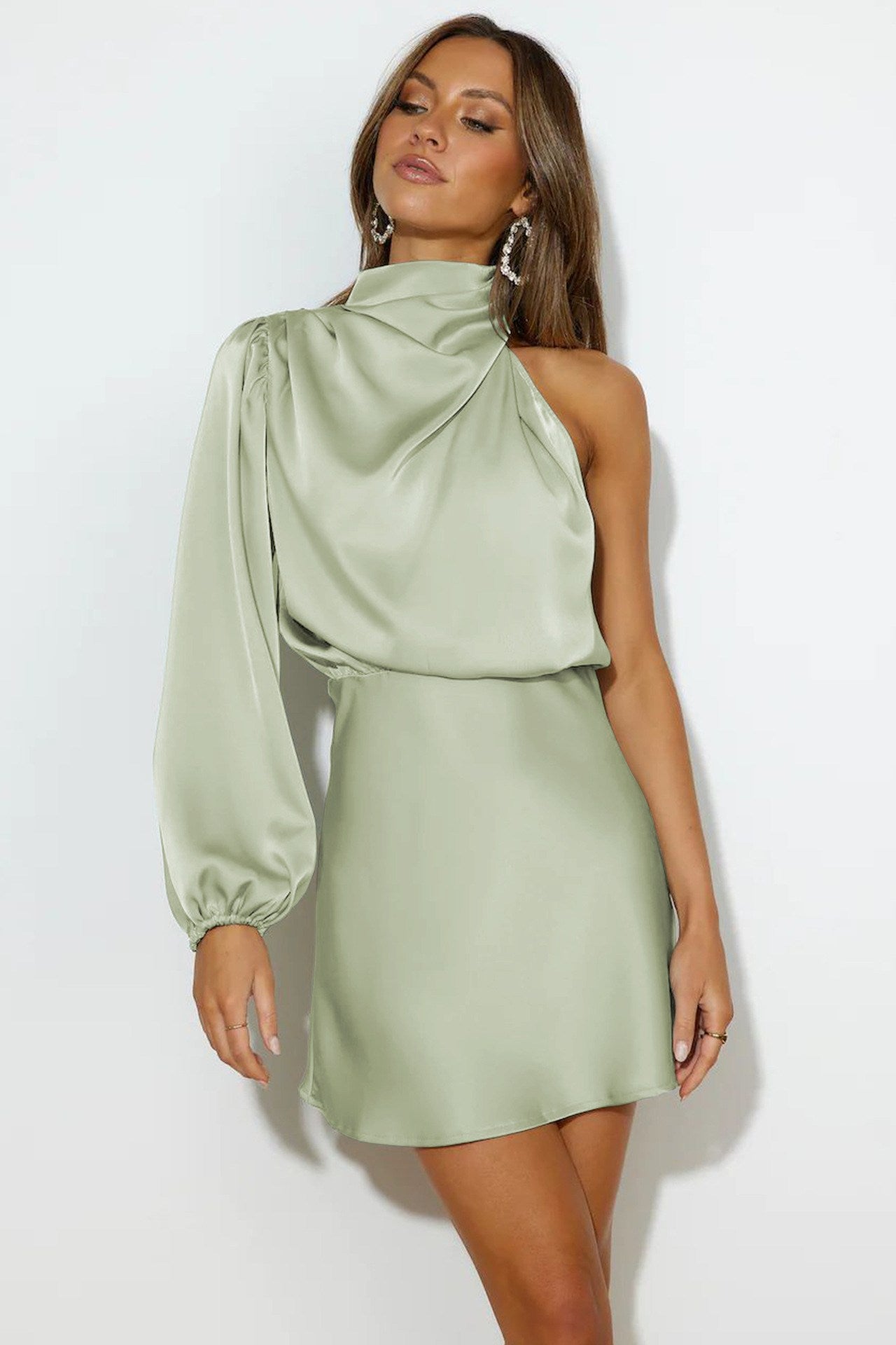 Woman in sage green satin one-shoulder mini dress