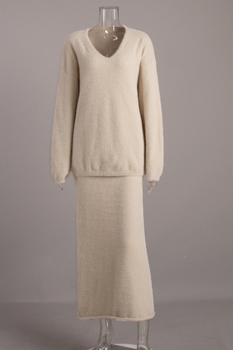 Woman in off-white boucle knit sweater and maxi skirt set with fuzzy slippers
