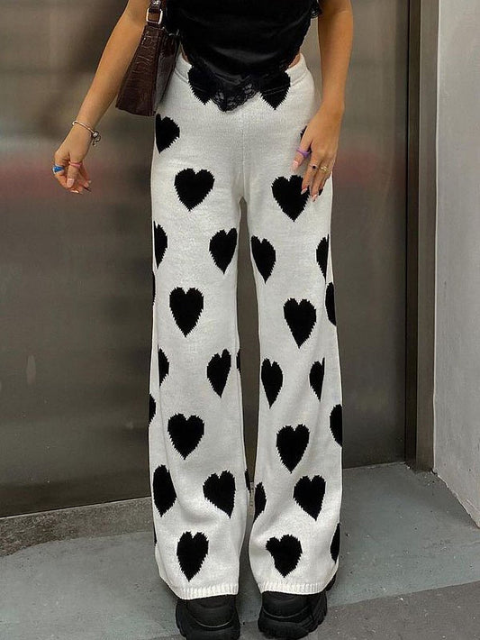 Woman wearing white ribbed knit pants with black heart print