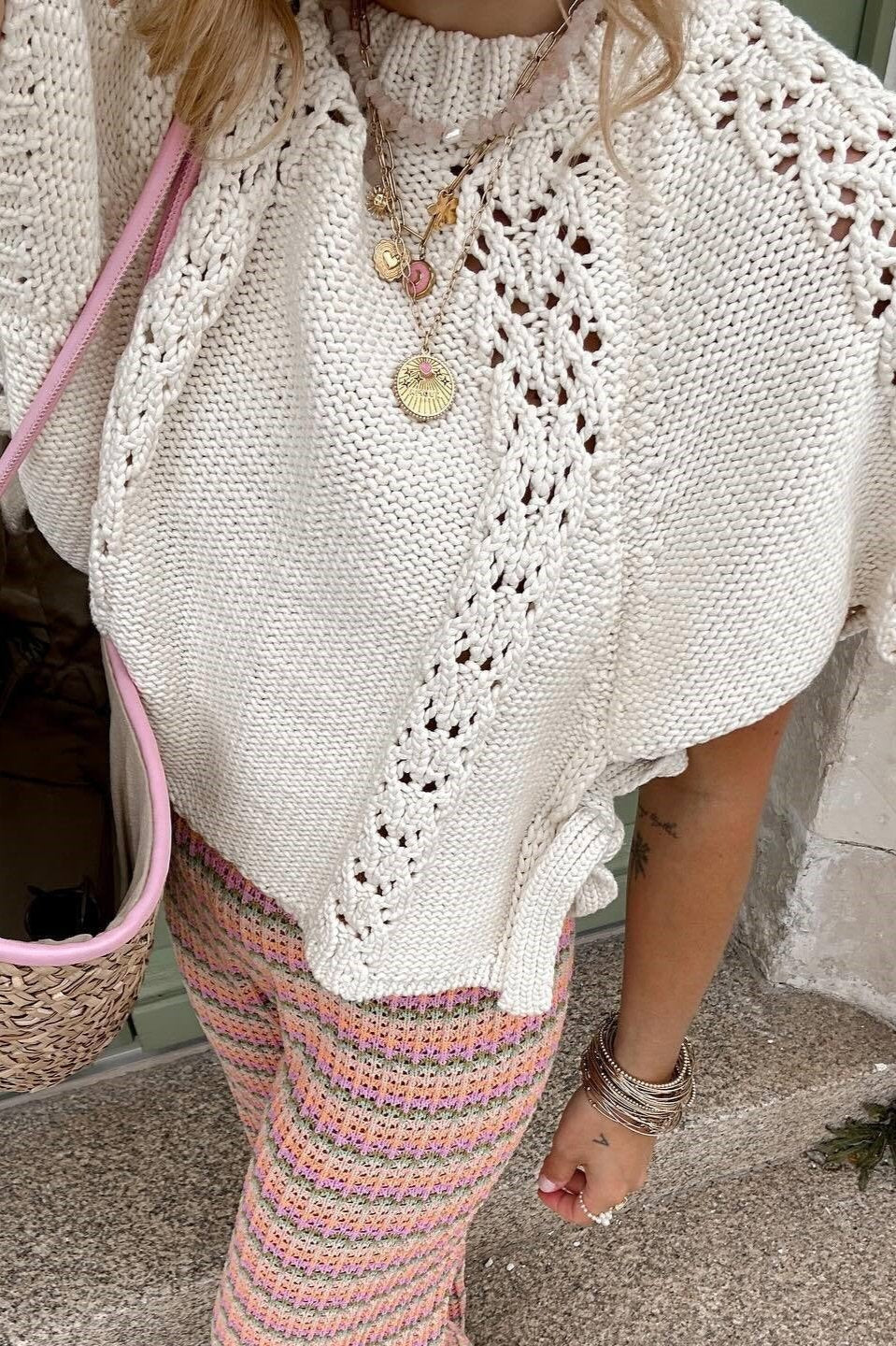 Woman in ivory crochet poncho with patterned pants