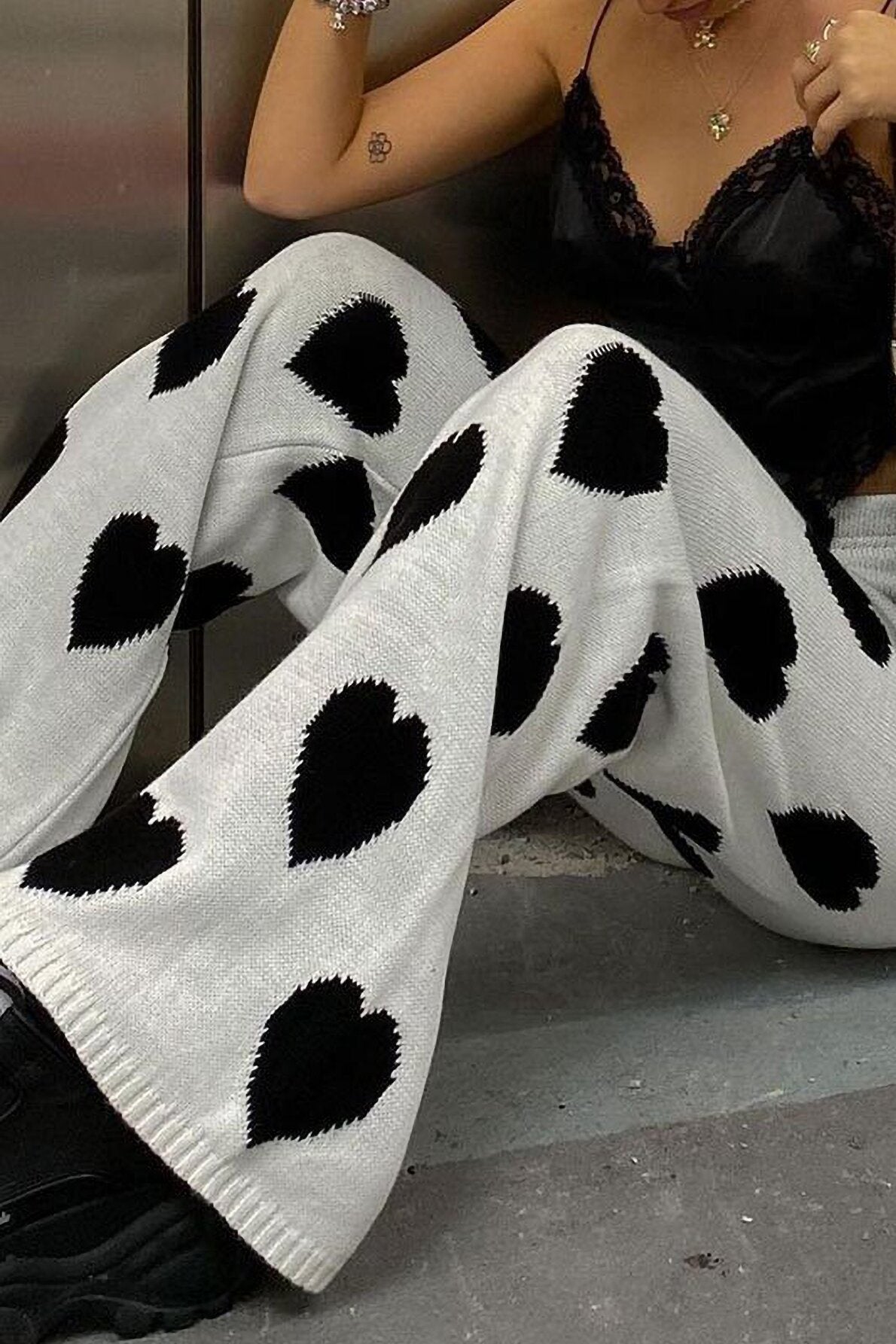Woman wearing white ribbed knit pants with black heart print