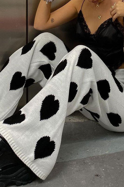 Woman wearing white ribbed knit pants with black heart print