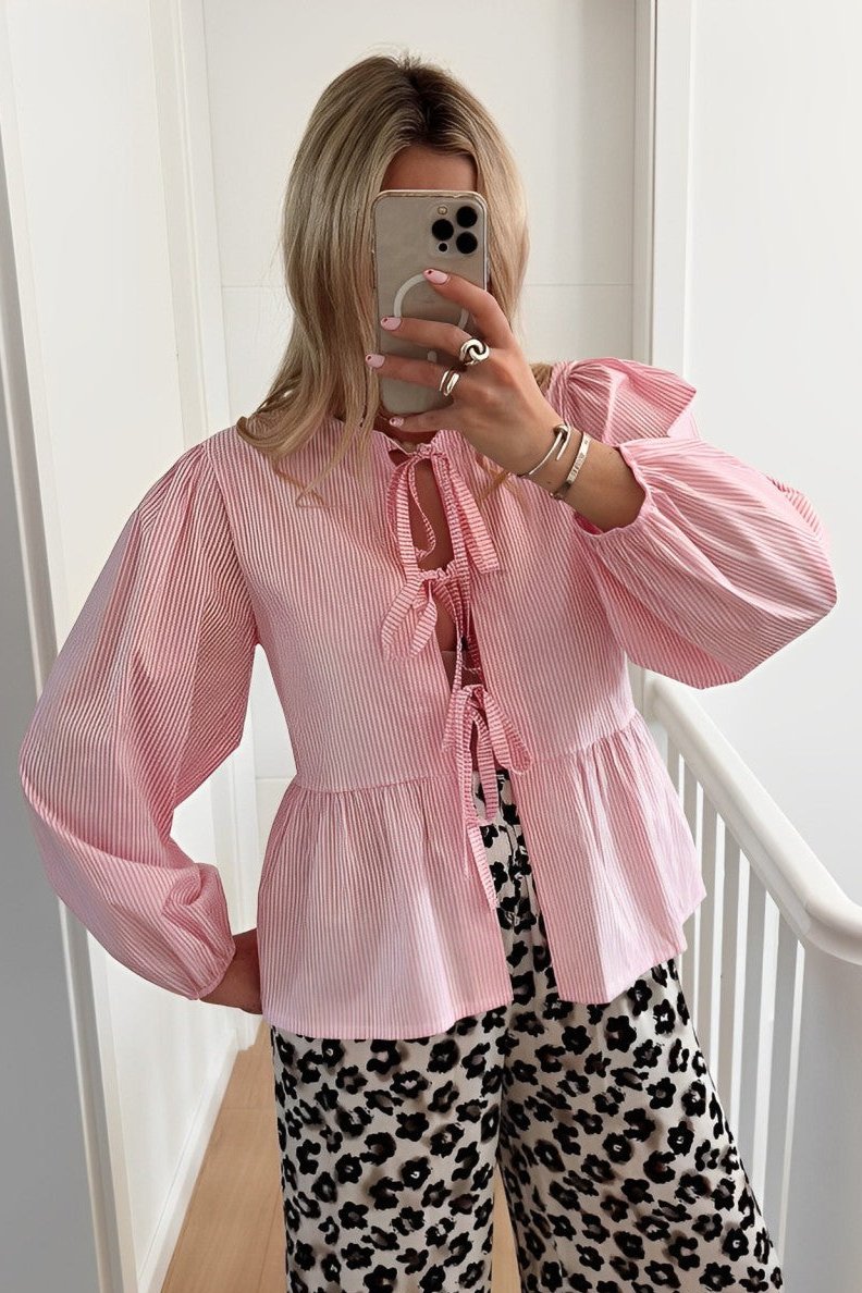 Woman in blue and white striped tie-neck blouse