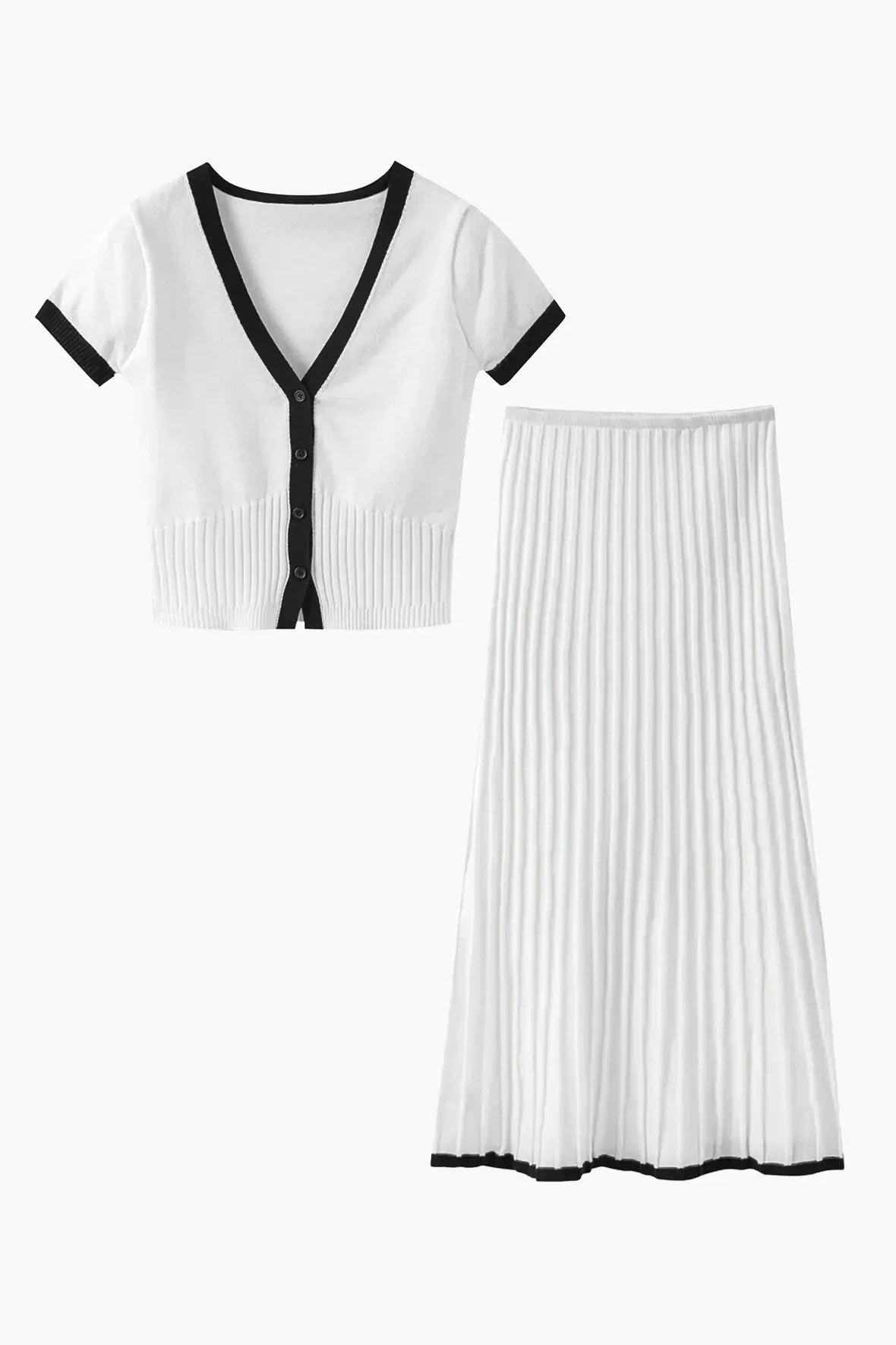 Woman in white ribbed knit crop top and pleated skirt with black trim standing on stairs.