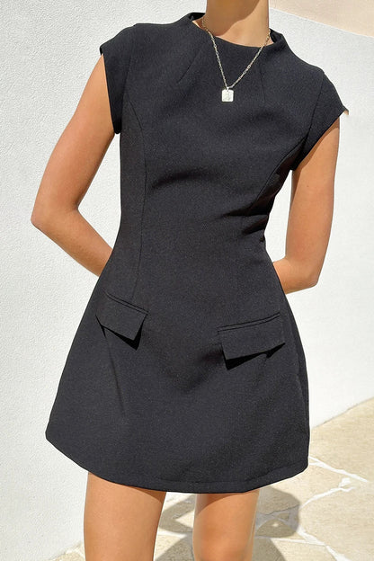 Woman in black crepe mini dress with red purse