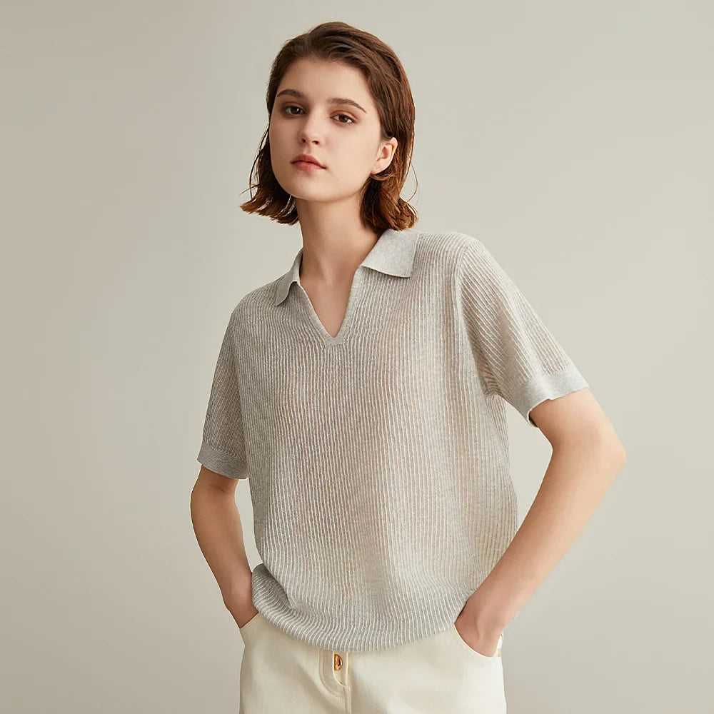 Woman wearing a light gray ribbed knit polo shirt.