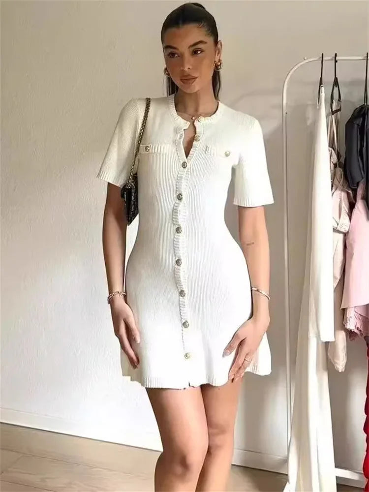 Woman in ivory boucle knit dress with brown handbag