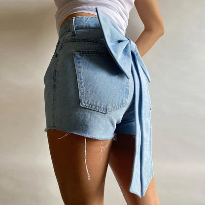 Back view of light wash denim shorts with large bow detail