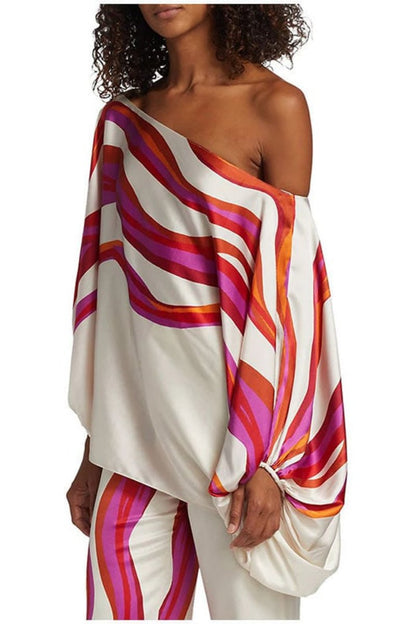 Woman in ivory satin pant set with pink and orange wave print
