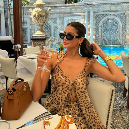 Woman in leopard print chiffon maxi dress with tan handbag