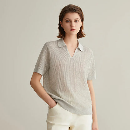 Woman wearing a light gray ribbed knit polo shirt.