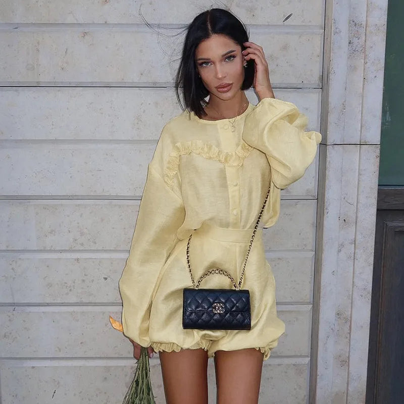 Woman in yellow linen romper with black quilted handbag
