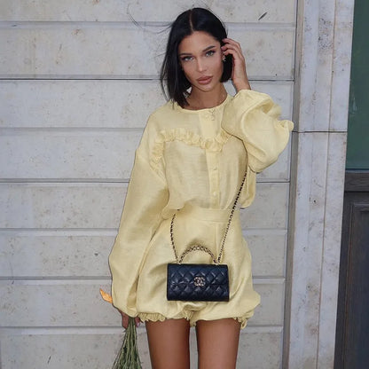 Woman in yellow linen romper with black quilted handbag