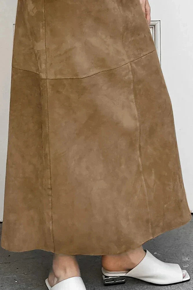 Woman wearing camel suede maxi skirt with white knit cardigan