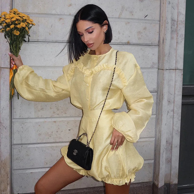 Woman in yellow linen romper with black quilted handbag