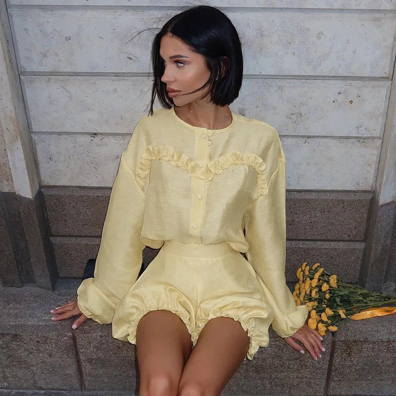 Woman in yellow linen romper with black quilted handbag