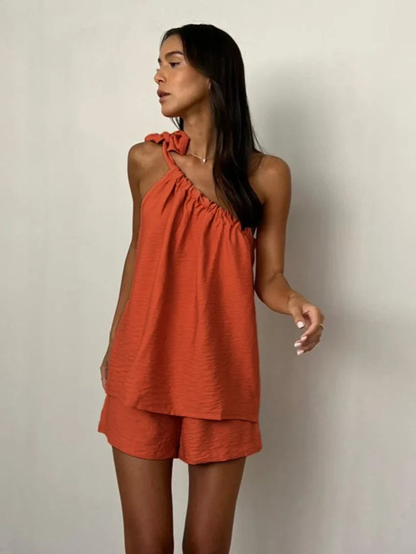 Woman wearing a rust-colored one-shoulder top and shorts set
