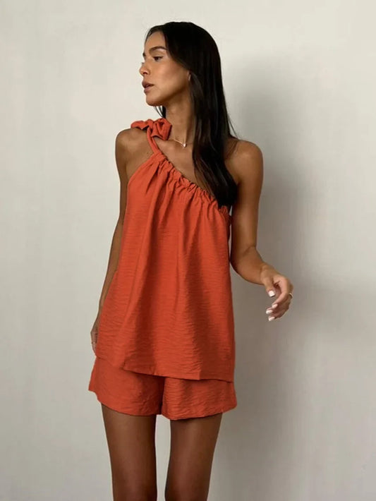 Woman wearing a rust-colored one-shoulder top and shorts set