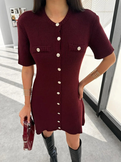 Woman in ivory boucle knit dress with brown handbag