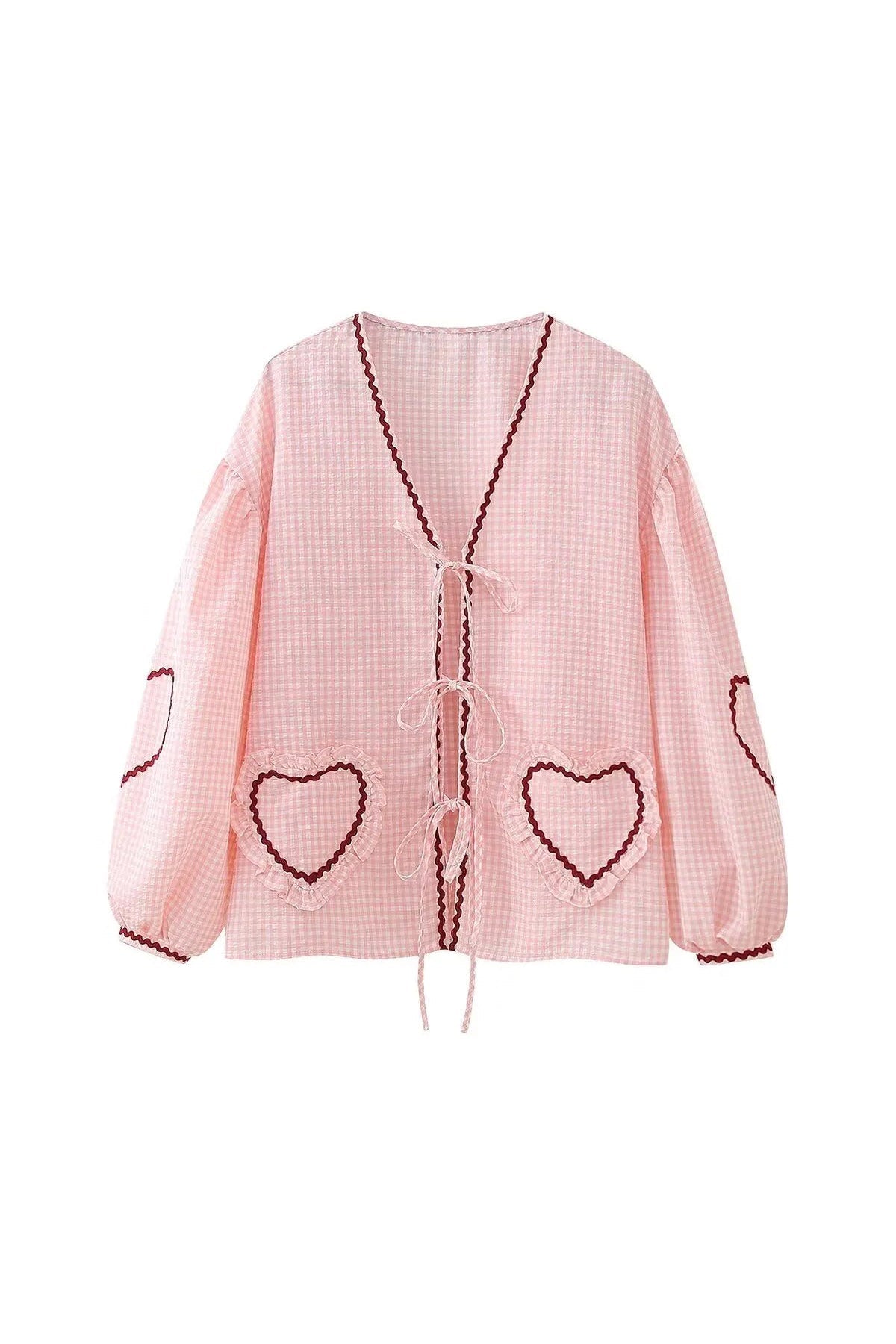 Woman in pink gingham blouse with heart pockets and denim shorts