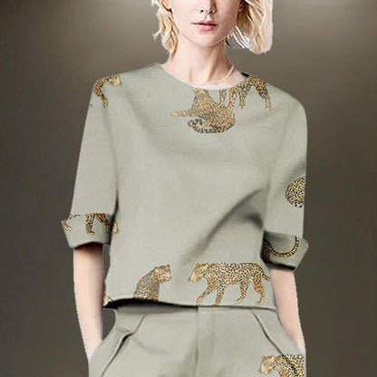 Woman wearing a sage green linen blend two-piece set with leopard print.