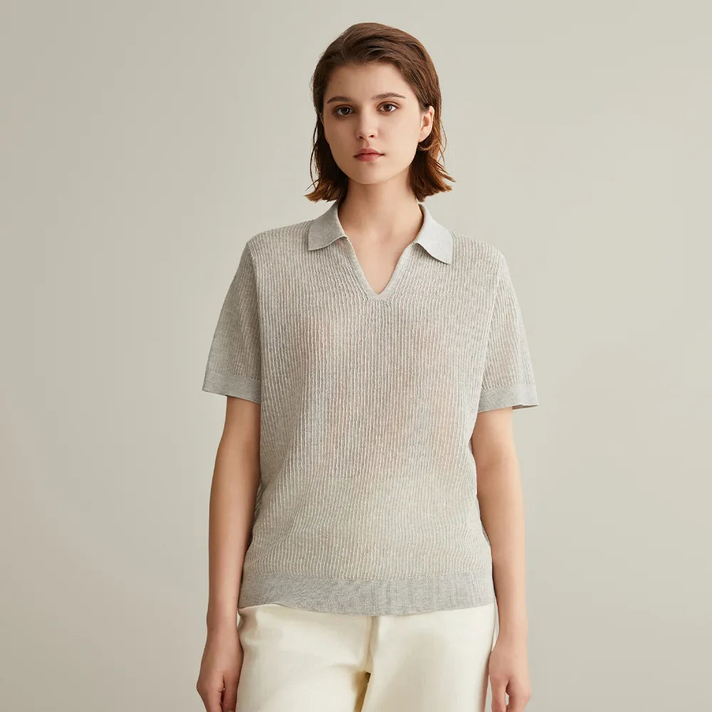 Woman wearing a light gray ribbed knit polo shirt.